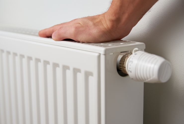 uomo con mano sui termosifoni 