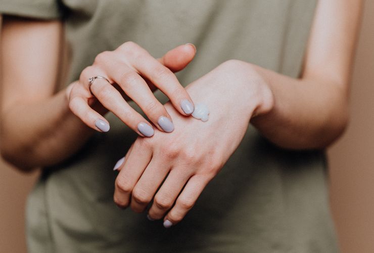 donna che mette crema sulle mani