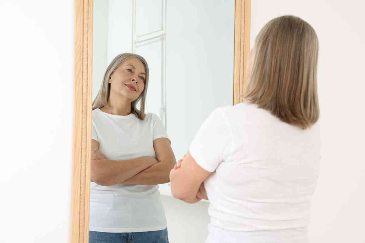 donna si guarda allo specchio